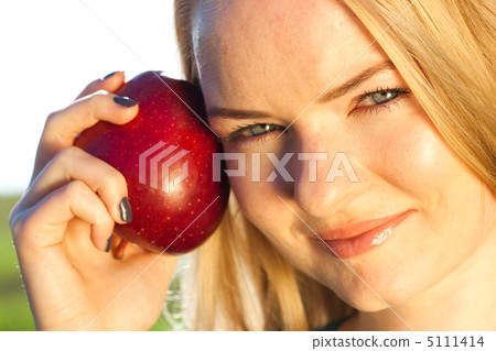 portrait of a beautiful young woman with apple  outdoor 5111414