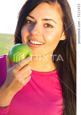 portrait of a beautiful young woman with apple  outdoor 5111415