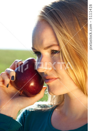 portrait of a beautiful young woman with apple  outdoor 5111416