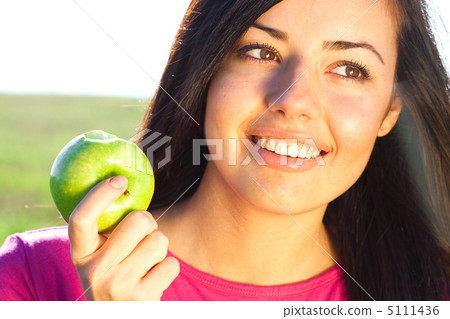 portrait of a beautiful young woman with apple  outdoor 5111436