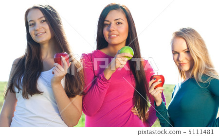 portret of three young beautiful woman with apple on the  sky ba 5111481