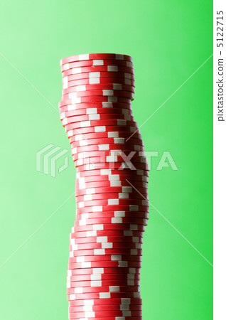 Stack of red casino chips against green background 5122715