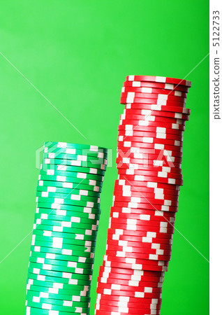 Stack of red and green casino chips against green background Stack of red and green casino chips against green background 5122733