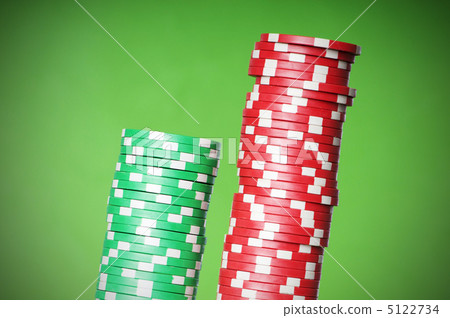 Stack of red and green casino chips against green background 5122734