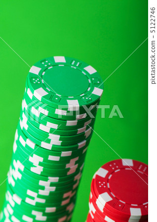 Stack of red and green casino chips against green background Stack of red and green casino chips against green background 5122746