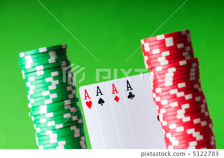 Casino chips and four aces against green background Casino chips and four aces against green background 5122783