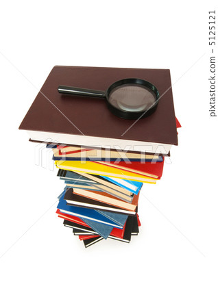 Magnifying glass over the stack of books Magnifying glass over the stack of books 5125121