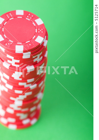 Stack of red casino chips against green background 5125714