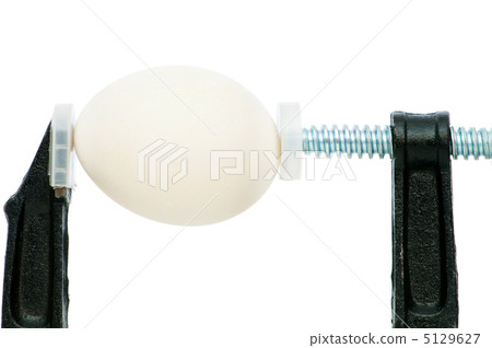 Strength concept with egg and clamp on white 5129627