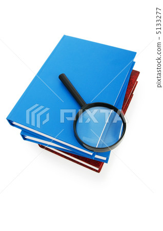 Magnifying glass over the stack of books 5133277
