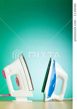 Modern electric iron against the colorful background 5136080