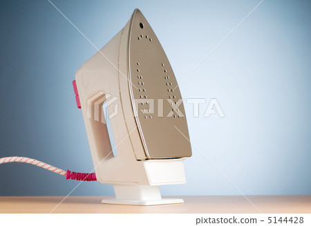Modern electric iron against the colorful background Modern electric iron against the colorful background 5144428