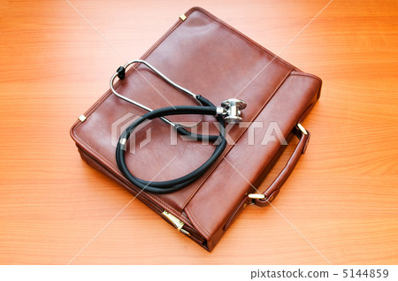 Doctor's case with stethoscope against wooden background 5144859