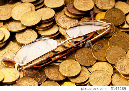 Many coins and reading glasses as business concept 5145289