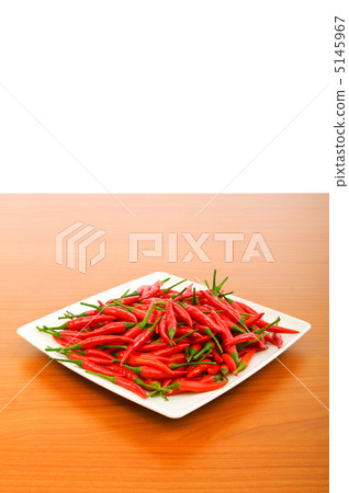 Hot peppers in the plate on wooden table Hot peppers in the plate on wooden table 5145967