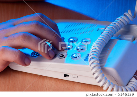 Hands dialing phone buttons in the darkness 5146129