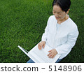 Senior women who enjoys PC on the lawn 5148906