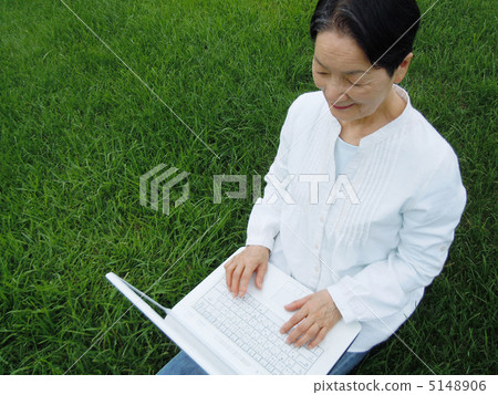 Senior women who enjoys PC on the lawn Senior women who enjoys PC on the lawn 5148906