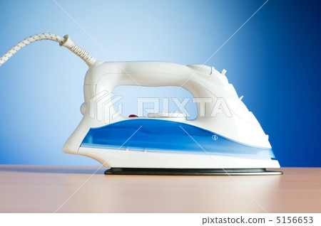 Modern electric iron against the colorful background Modern electric iron against the colorful background 5156653