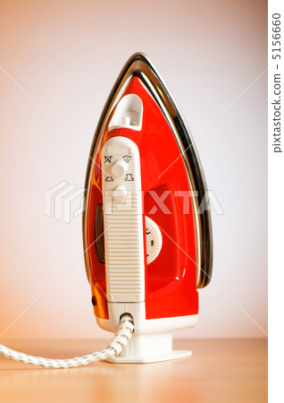 Modern electric iron against the colorful background 5156660