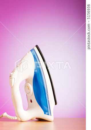 Modern electric iron against the colorful background 5156936