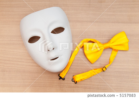 Masks and bow ties on the wooden background Masks and bow ties on the wooden background 5157083
