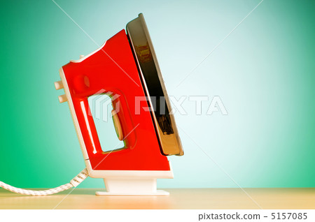 Modern electric iron against the colorful background Modern electric iron against the colorful background 5157085