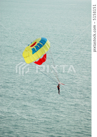 Man on the parachute over the evening sun 5158151