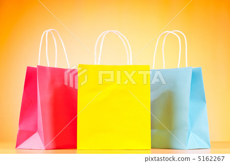 Colourful paper shopping bags against gradient background 5162267