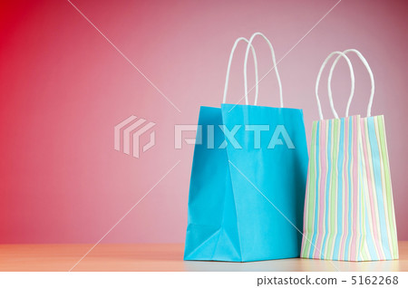 Colourful paper shopping bags against gradient background 5162268