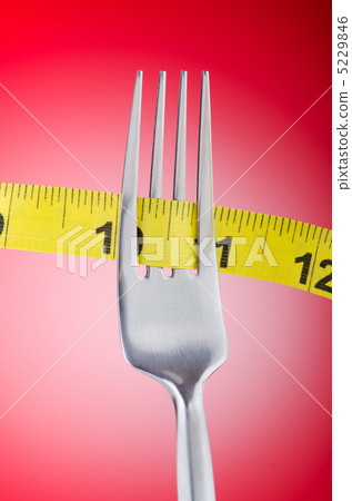 Dieting concept with fork and meter Dieting concept with fork and meter 5229846