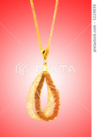 Golden jewellery against gradient background 5229939