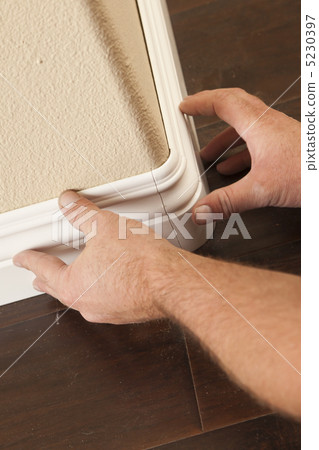 Contractor Installing New Baseboard with Bull Nose Corners and N 5230397
