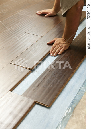 Man Installing New Laminate Wood Flooring Man Installing New Laminate Wood Flooring 5230410