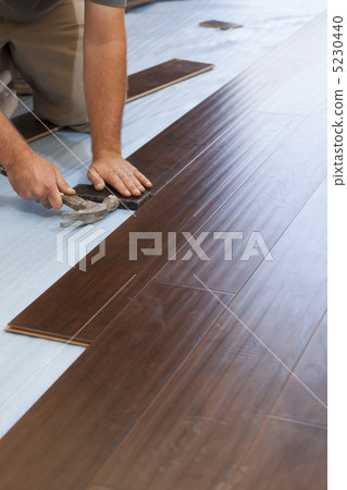 Man Installing New Laminate Wood Flooring Man Installing New Laminate Wood Flooring 5230440