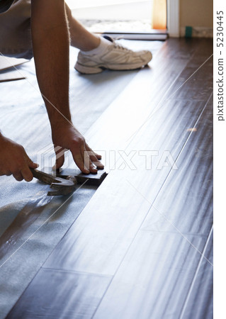 Man Installing New Laminate Wood Flooring Man Installing New Laminate Wood Flooring 5230445