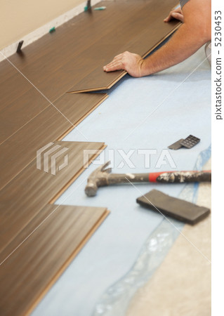 Man Installing New Laminate Wood Flooring Man Installing New Laminate Wood Flooring 5230453