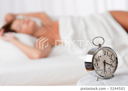 White lounge - Alarm clock standing on white bed 5244581