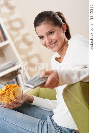 Students - Smiling female teenager watching TV Students - Smiling female teenager watching TV 5245552