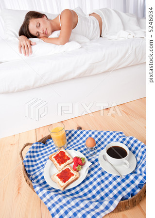 Woman having homemade breakfast lying in bed Woman having homemade breakfast lying in bed 5246034