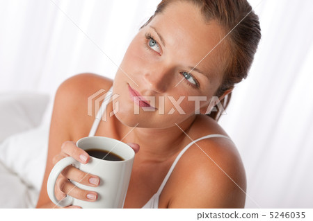 Beautiful young woman holding cup of coffee Beautiful young woman holding cup of coffee 5246035