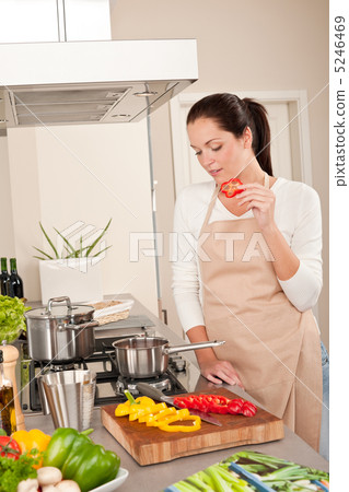 Happy woman biting red pepper in modern kitchen Happy woman biting red pepper in modern kitchen 5246469