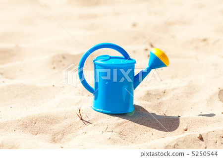watering can on a background of sand 5250544