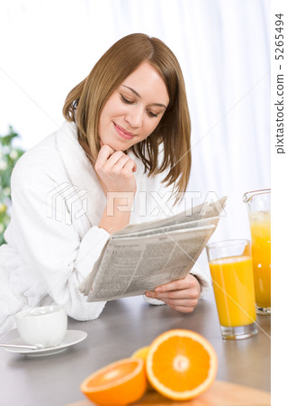 Breakfast - Smiling woman reading newspaper in kitchen Breakfast - Smiling woman reading newspaper in kitchen 5265494