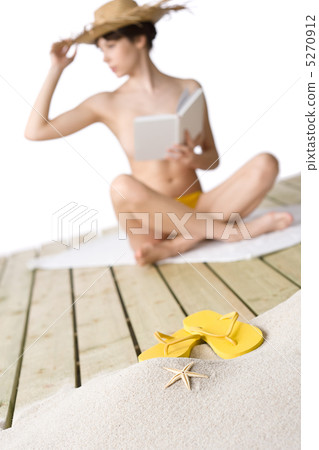 Beach - starfish with flip-flop on sand, woman in background 5270912