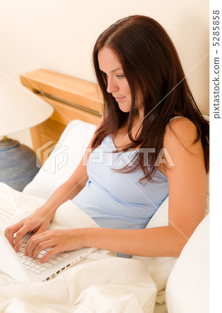 Beautiful woman working on computer in bed Beautiful woman working on computer in bed 5285858