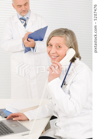 Medical team senior female phone male colleague Medical team senior female phone male colleague 5287476