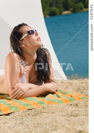 Summer beach young woman sunbathing in bikini 5287641