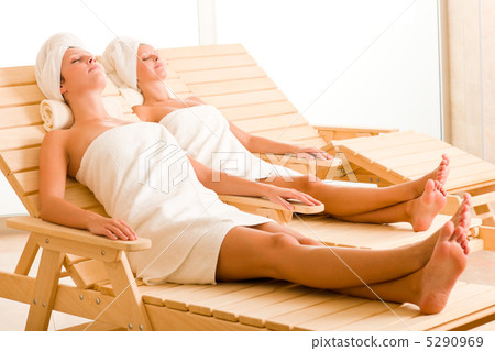 Beauty spa room two women relax sun-beds 5290969