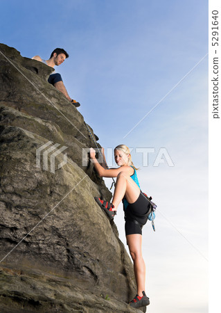 Woman climbing up rock man hold rope 5291640
